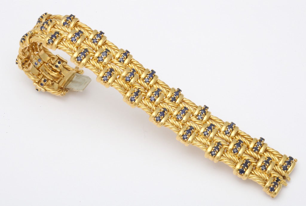 A 1960s Tiffany & Co. 18K yellow gold bracelet, set with over six carats of matched blue sapphires, in a flexible pattern of rope-like cords. Arm moment gives an illusion of each cord twisting individually. Tiffany and gold marks. Fits a 7 1/2 inch