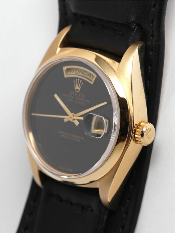 Rolex 18k yellow gold Day-Date President wristwatch, Ref. 18038, 36mm diameter case with smooth bezel and scarce black onyx dial with gold day and date frame and gold applied Rolex logo crown. Serial number 6.1 million, circa 1979. 

Offered on