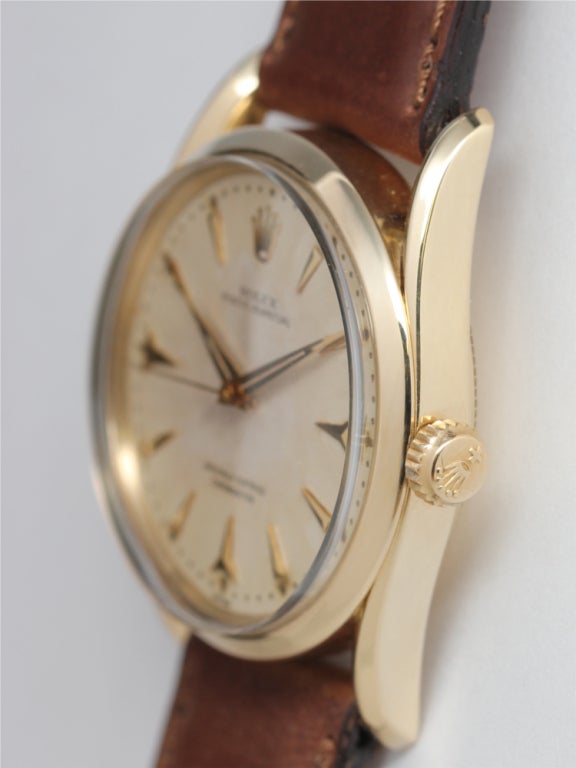 Rolex 14k yellow gold Bombé, Ref. 6590, serial 618000, circa 1960, super sharp condition curved-lug case, very pleasing original antique white dial with light warm patina, and with gold applied shark's teeth markers and tapered dauphine hands.