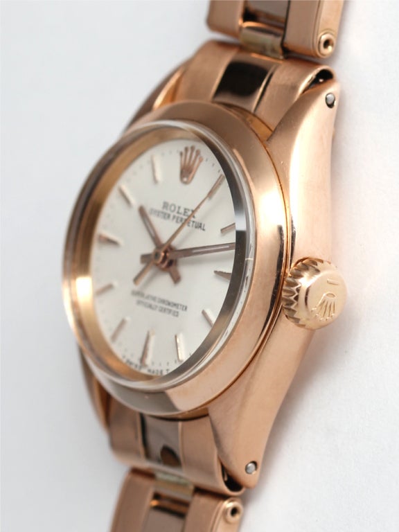 Rolex lady's 18k pink gold Oyster Perpetual wristwatch, circa 1956. 27mm diameter case with smooth bezel, antique white dial with pink applied indexes with pink baton hands, self-winding movement with sweep seconds. With associated 18k pink gold
