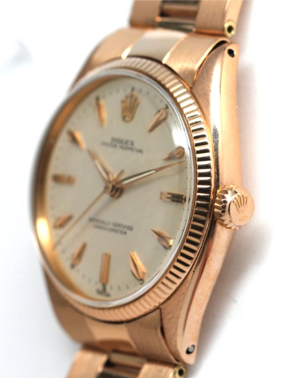 Rolex 18k rose gold Oyster Perpetual wristwatch, Ref. 6567, serial 128XXX, circa 1955. 34mm diameter case with sloped engine turned bezel and silvered matte dial with pink applied marquise shaped indexes and tapered dauphine hands. Self-winding