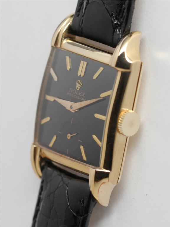 Rolex 18k yellow gold square medium sized dress model, 26.5 x 38mm, with contoured fluted lugs circa 1950s. With glossy black restored dial with gold applied indexes and gold tapered hands. 17-jewel manual-wind calibre 10 1/2 movement with