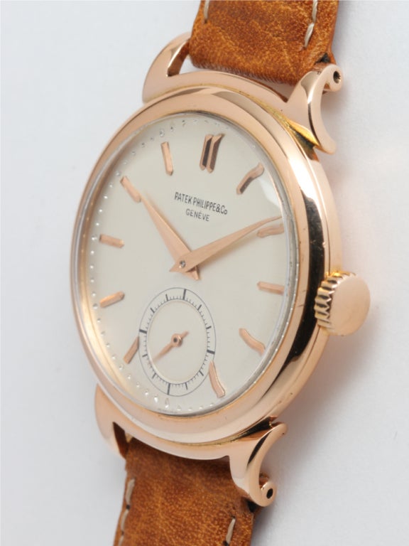 Patek Philippe 18k pink gold wristwatch, Ref. 1491, circa 1950s, so called Curly Lug model. Round case with wide rounded bezel and large extended curly lugs. With very pleasing restored matte silver dial with applied pink figures and pink tapered