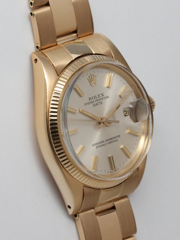 Rolex 18k yellow gold Oyster Perpetual Date wristwatch, Ref. 1500, serial 5.5 million, circa 1978. 34mm diameter case with fluted bezel and beautiful original silvered satin dial with gold applied indexes and gold baton hands. With associated 18k