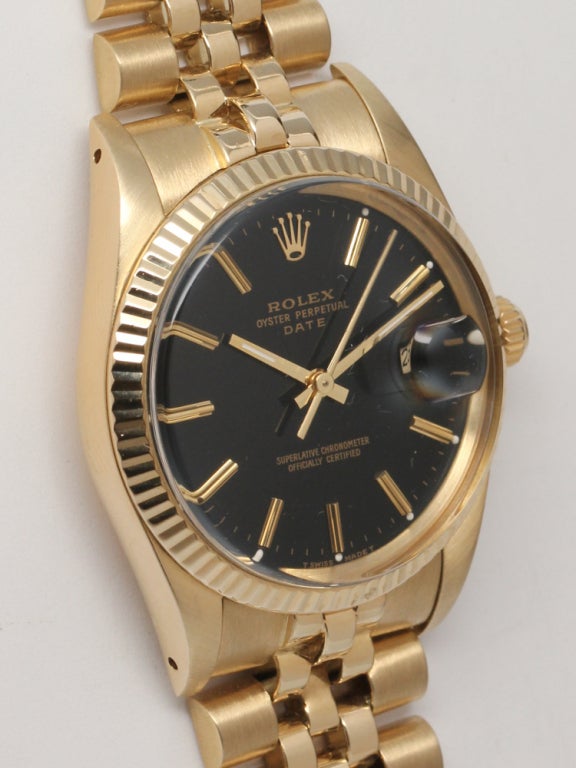 Rolex Oyster Perpetual Date 14k yellow gold, Ref. 15037, serial 9.2 million, circa 1985. 34mm diameter case with fluted bezel and pleasing original glossy black dial with applied gold indexes and gold baton hands. With associated 14k yellow gold D