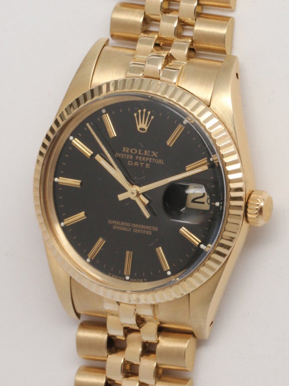 Rolex Oyster Perpetual Date 14K YG ref#15037, serial# 9.2 million circa 1985. 34mm diameter case with fluted bezel and pleasing original glossy black dial with applied gold indexes and gold baton hands. With associated 14K YG D link Jubilee bracelet