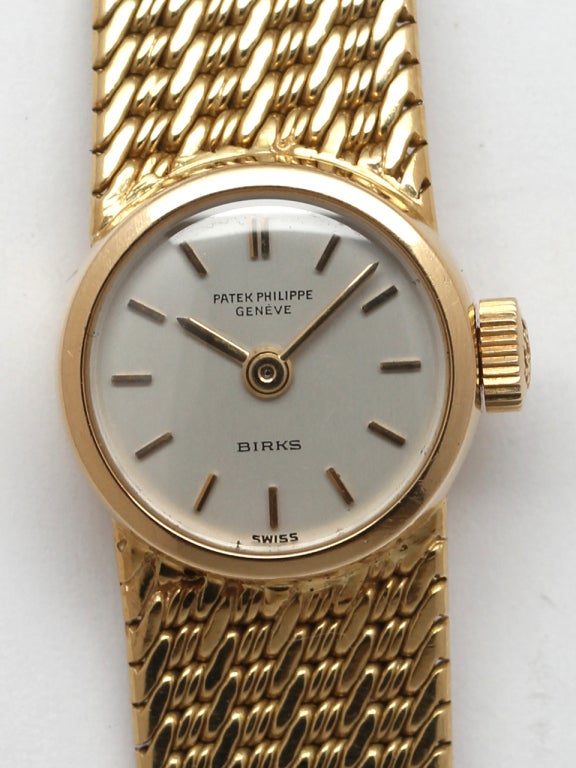 Patek Philippe 18k yellow gold Calatrava bracelet watch with original signed Patek heavy woven bracelet. Original mint condition matte silvered dial with applied gold indexes and gold baton hands and signed by Canadian retailer Birks. 18-jewel