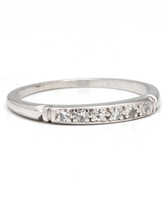 Platinum partial diamond eternity band set with 6 bead set diamonds approximately 0.09 carat total weight with carved details at shanks. 2mm wide, size 5.25, circa 1940's. To be worn alone, or stacked.

Stk# 42283