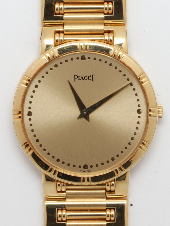 Beautiful condition man's Piaget 18k yellow gold Dancer model wristwatch, circa 1990s. Round case with textured bezel and gilt dial. Tapered gold hands. With 18k yellow gold integral high style full length bracelet and nearly invisible clasp.