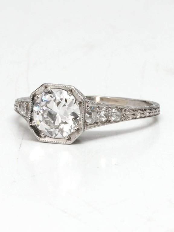 Platinum solitaire with approx 0.90ct old European cut diamond center stone set in an octagonal setting G color VS1 clarity and 3 graduated size bead set diamonds on each side. Gorgeous, open wire work on gallery & embellished with hand engraving on