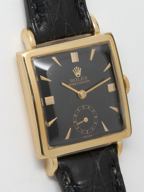 Rolex 18k yellow gold square medium size dress model with extended lugs and restored glossy black dial with applied indexes and baton hands. 17-jewel manual-wind caliber 10 1/2 movement with subsidiary seconds. With accompanying black crocodile