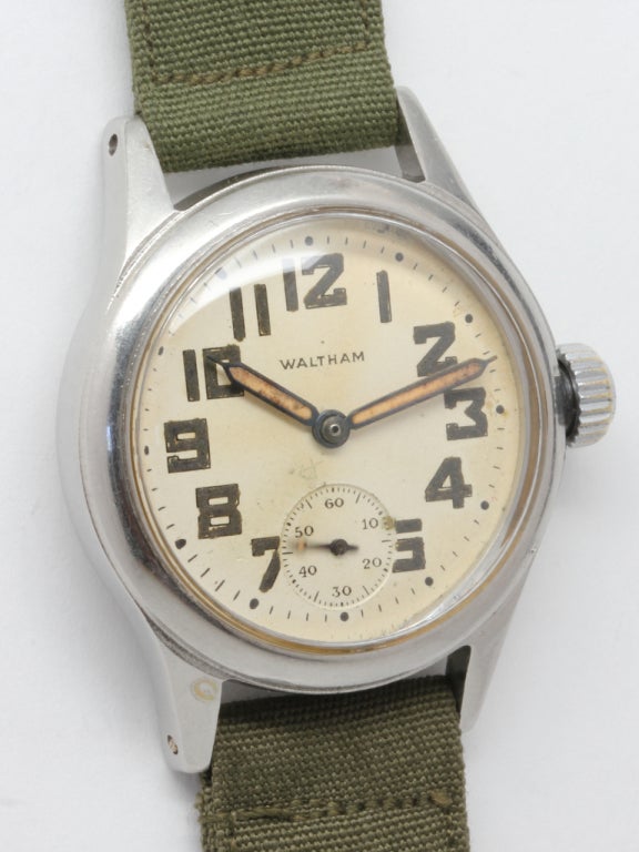 Waltham base metal WWII-era military-issue wristwatch, original silvered dial with luminous indexes and luminous wide pencil hands. 15-jewel manual-wind movement with subsidiary seconds. Screw down case back signed OF 166195. 

Offered on military