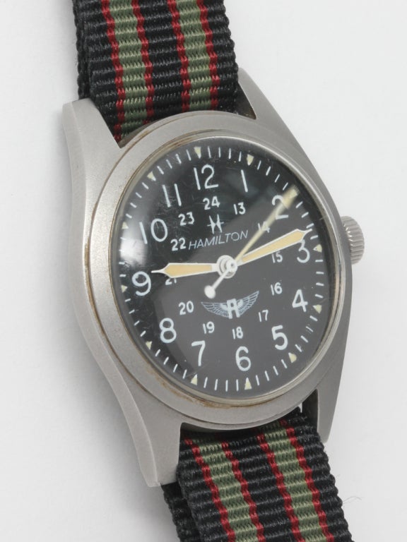 Hamilton steel military-style wristwatch, with medium size 32mm brushed finish case, circa 1970s. Featuring matte black dial with luminous figures and inner 24 hour track and winged A logo. 17-jewel manual-wind movement with sweep seconds and hack