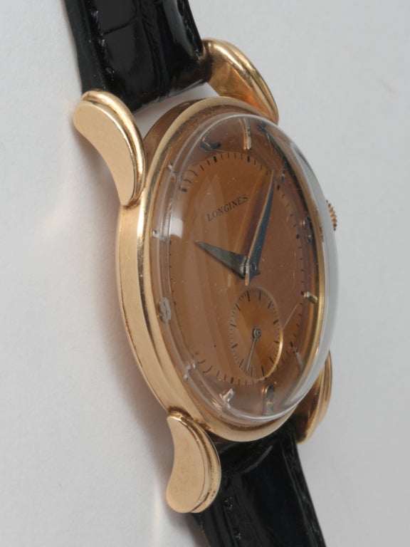 Longines 14k rose gold wristwatch, circa 1950s. 31 X 39mm case with fluted bombe lugs, with an original salmon dial with applied indexes and dauphine hands. 17-jewel manual-wind movement with subsidiary seconds. Great looking, very sophisticated