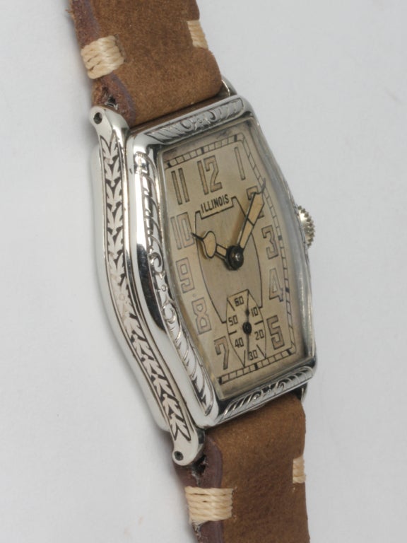 Illinois white gold-filled Mate wristwatch, circa 1930s. Tonneau case with engraved bezel and very pleasing original two-tone dial with luminous indexes and hands. 17-jewel manual-wind calibre 307 movement with subsidiary seconds.

Offered on your
