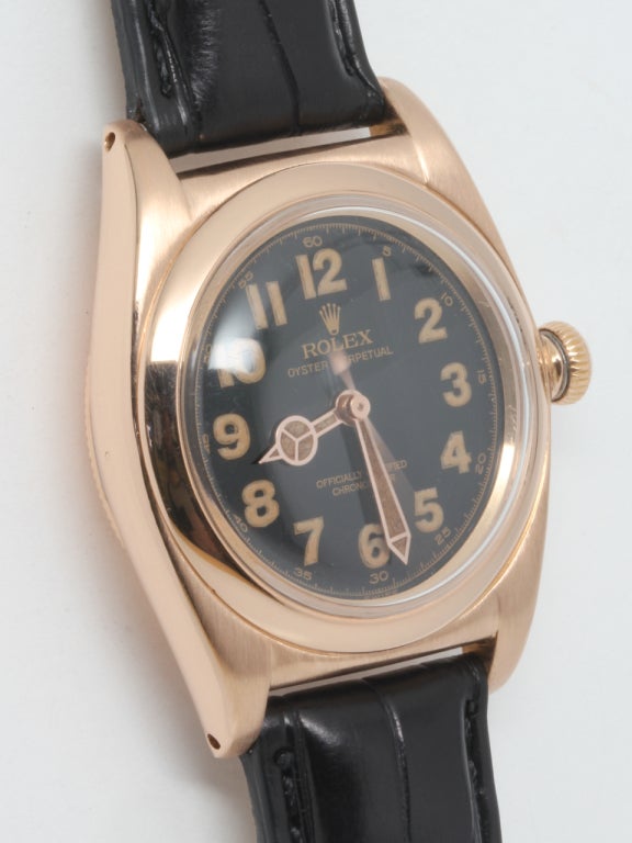 Rolex 18k rose gold Bubbleback wristwatch, circa 1940s. Classic vintage model, 32mm tonneau case with smooth bezel, beautifully restored glossy black dial with luminous indexes and matching mercedes hands. Self-winding calibre N/A movement with