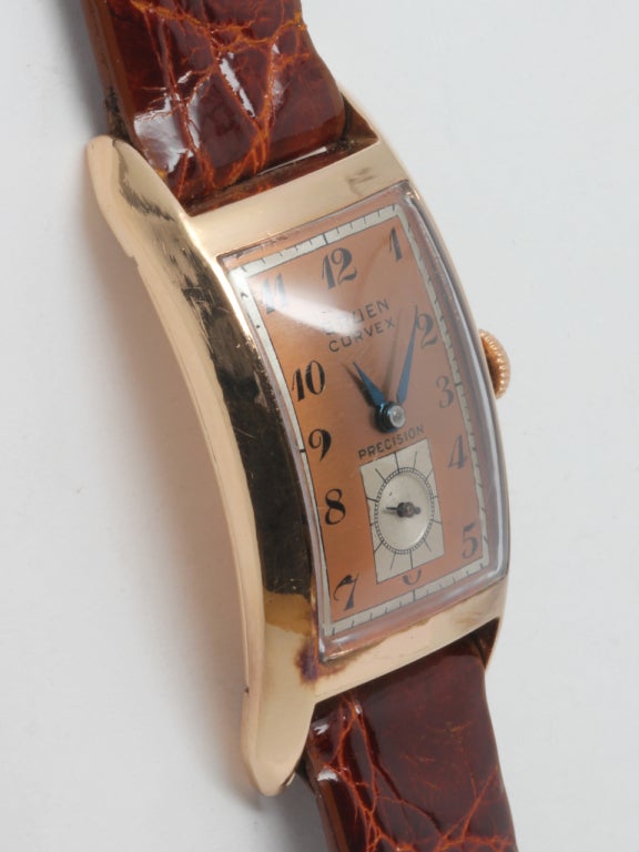 Classic 14k rose gold Gruen Curvex wristwatch, circa 1940s, featuring a curved case to contour to the shape of the wrist, a beautiful original two-tone pink and satin dial with black stylized numbers and blued steel hands. Calibre 440 17-jewel