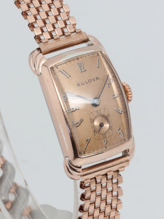 Bulova rose gilt tonneau wristwatch, circa 1940s, with stepped rounded Art-Deco-style lugs and pleasing rose dial with black and white shadow numerals with blued steel hands. 17-jewel manual-wind movement with subsidiary seconds. With period