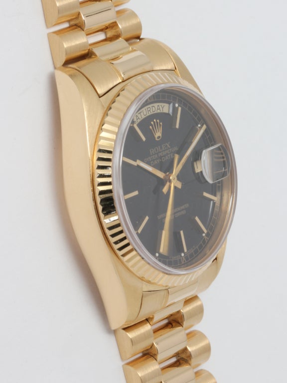 Rolex 18k yellow gold Day-Date wristwatch, very early sapphire crystal model, serial number 5.3 million, circa 1977. 36mm diameter case with fluted bezel and sapphire crystal. Original gloss black dial with applied gold indexes and hands. Self