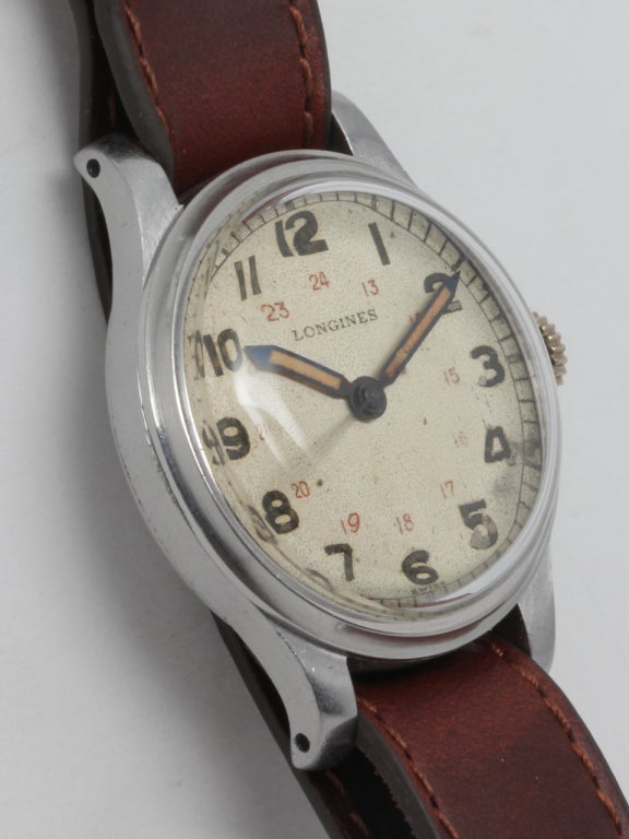 Longines stainless steel military-style wristwatch, circa 1940s. 32 X 45mm case with heavy snap back. Original matte silvered dial with luminous indexes, wide luminous pencil hands and inner 24-hour indications printed in red. 17-jewel manual-wind