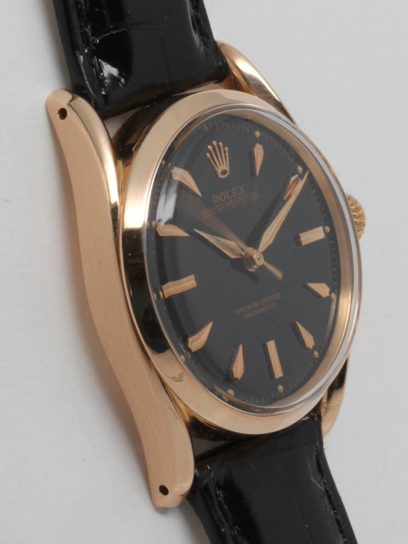 Rolex 18k rose gold Oyster Perpetual bombe wristwatch, Ref. 5018, circa 1967, 33 x 39mm case with turned lugs, with beautifully restored glossy black dial with applied marquise shaped indexes and dauphine hands. Scarce and striking model offered on