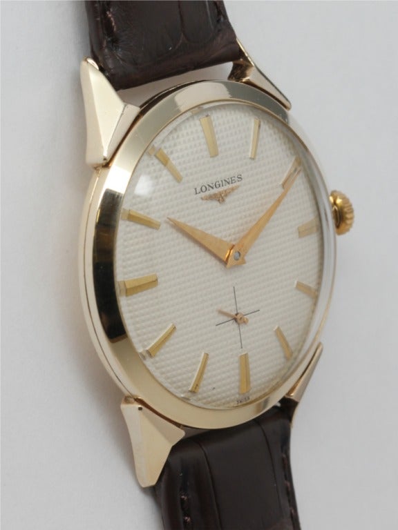Longines gold-filled wristwatch, circa 1950s, 17-jewel manual-wind movement, beautifully restored textured dial with applied indexes and dauphine hands, fancy case with faceted lugs. Great mid-century design. Offered on your choice of fine or exotic