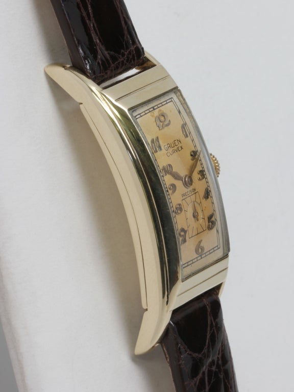 Gruen 14k yellow gold Curvex wristwatch, circa 1930s. Elongated 20 x 47mm case with curved back and stepped bezel. Silvered patinaed dial with raised gold Arabic numerals and gilt feuille hands. Powered by a Gruen caliber 330 manual-wind Curvex