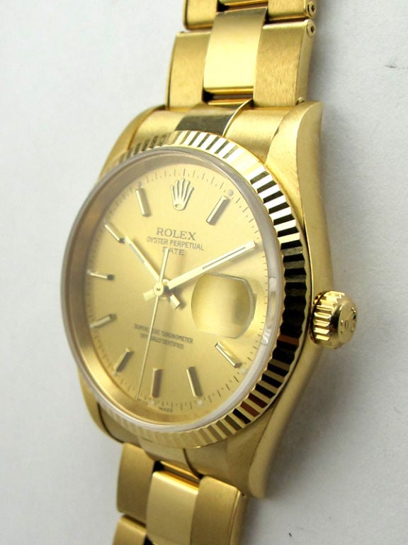Rolex 18K YG Oyster Perpetual Date ref #15008 34mm diameter case with fluted bezel. Sapphire crystal with quik set calibre 3135 movement circa 1990's. With original champangne dial with applied gold indexes and baton hands. With Rolex 18K YG riveted