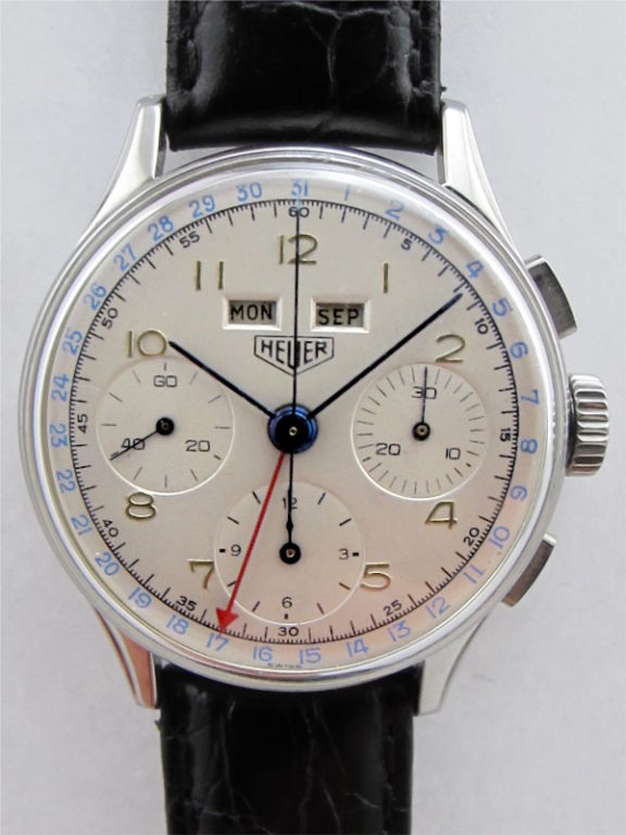 Heuer stainless steel triple calendar chronograph large 35 x 37.5 mm snap back case circa 1950 with restored matte silver dial with raised gold indexes, 3 registers, and windows for month and day and arrow tipped hand for date. Powered by Valjoux