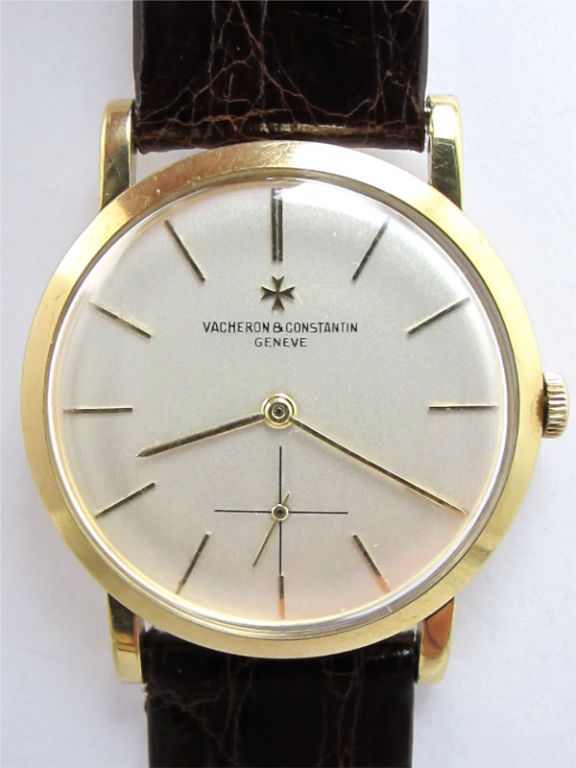 Vacheron 18K YG dress model 33mm diameter case with sloped bezel and classic straight lugs circa 1960's. Original silver satin dial with thin applied indexes and hands, signed Vacheron and Constantin Geneve and with gold applied V & C logo cross.18