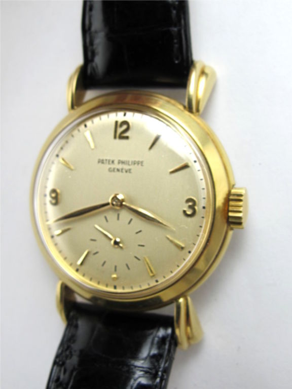 Patek Philippe 18K YG round case with large and pronounced flared lugs ref # 2453 circa 1950's. 33.5 x 41mm round case with heavy snap back, flared and fluted lugs movment serial # 959,xxx circa 1960's with matte silver original dial with gold