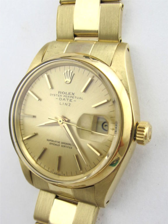 Rolex 14K YG Oyster Perpetual Date ref 1500 34mm diameter case with smooth bezel, original champagne dial double name LINZ for famous Swiss retailed. With stylized applied gold indexes and tapered gold baton hands. Serial # 1.0 miilion circa 1964.