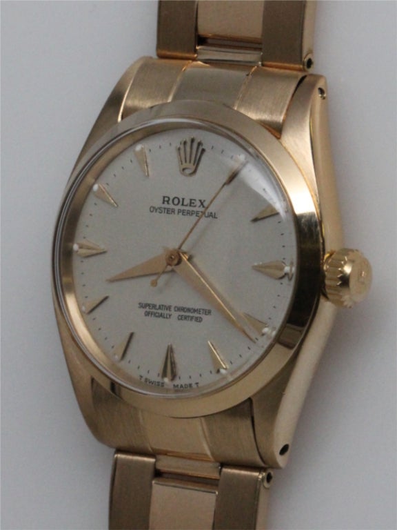 Rolex 18K YG Oyster Perpetual ref #6548 midsize 31mm diameter case with smooth bezel serial # 261,xxx circa 1957 with very pleasing silver satin dial with applied triangular indexes and tapered dauphine hands. With signed Rolex 18K YG riveted link