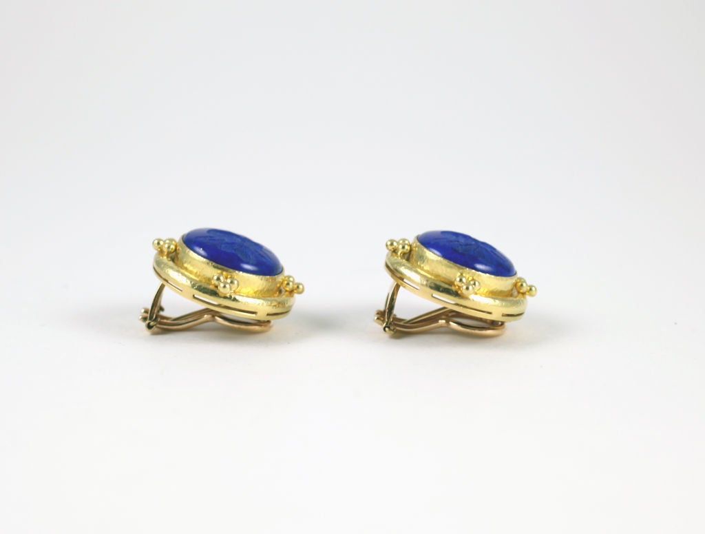 “Elizabeth Locke” 18k yellow gold and blue lapis earrings. Each earring features a cushion-shaped blue lapis with bee intaglio in a hammered gold bezel with collapsible posts.