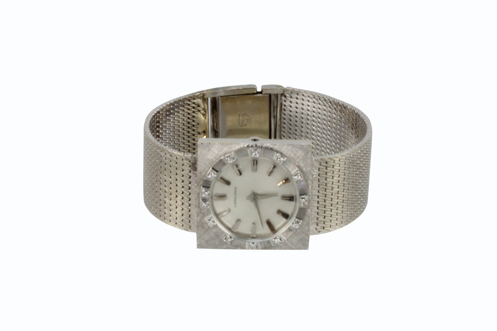 “Longines” 18k white gold vintage gent’s stem-wound watch with mesh bracelet in a square case. Diamonds line the bezel indicating the position of the numbers. Bracelet measures 6.75’’. Gross weight 55.6g Manual winding.