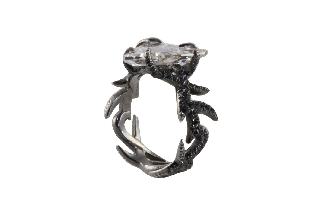This one of a kind, approximately 3 carat table diamond mounted onto a band of black diamond thorns. The ring is mounted in 18k black gold and is hand set.The diamond is of superior quality and clarity.