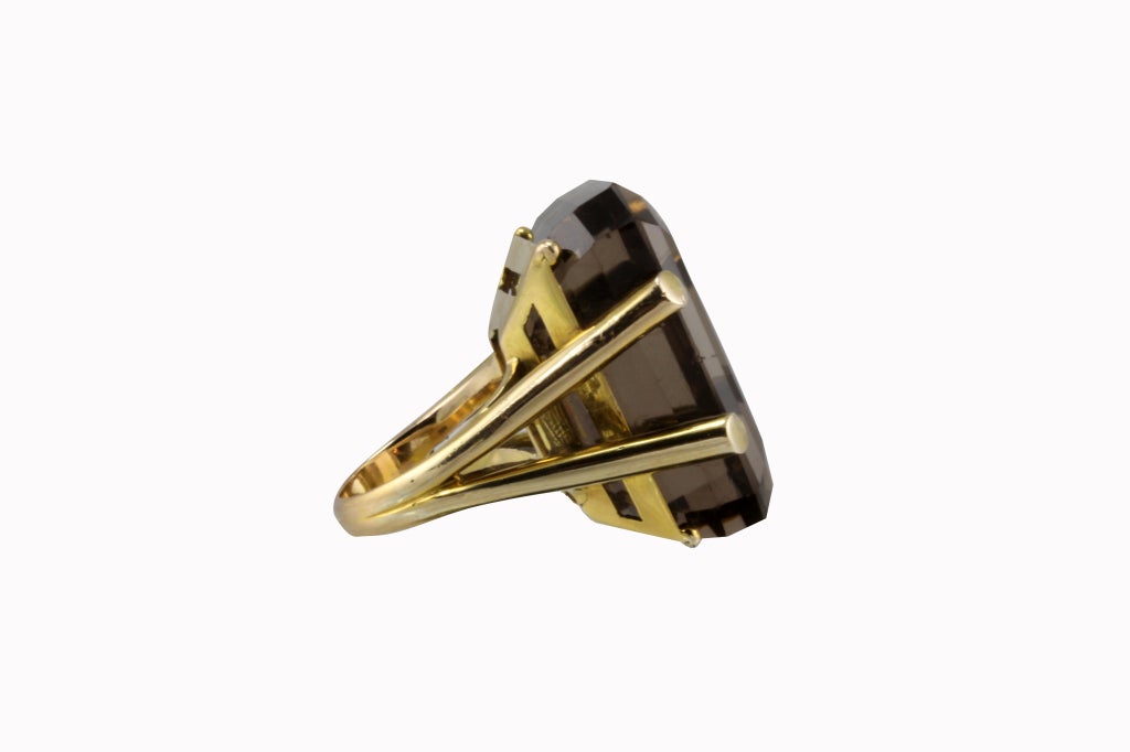 The ring is in 18k yellow gold and is a retro mounted very large 54 carat Smokey Topaz. The ring is a split shank tubular mounting and the stone is a step cut rectangular shape.