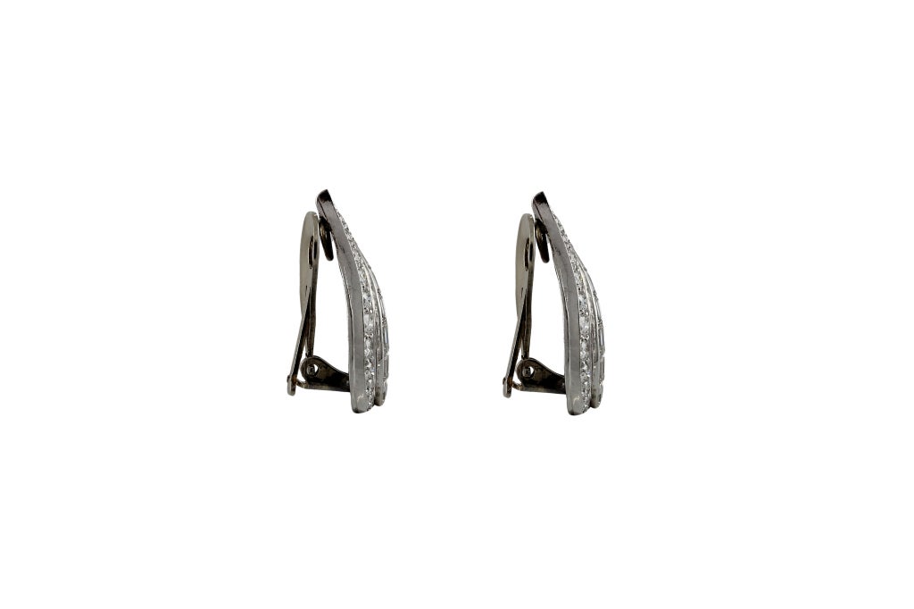 Hand-made vintage platinum leaf-like earrings with diamond baguettes and round brilliant diamonds. Each is channel-set with a row of six baguette diamonds, estimated total weight in the pair 1.14cts. Each earring is also bead set with round