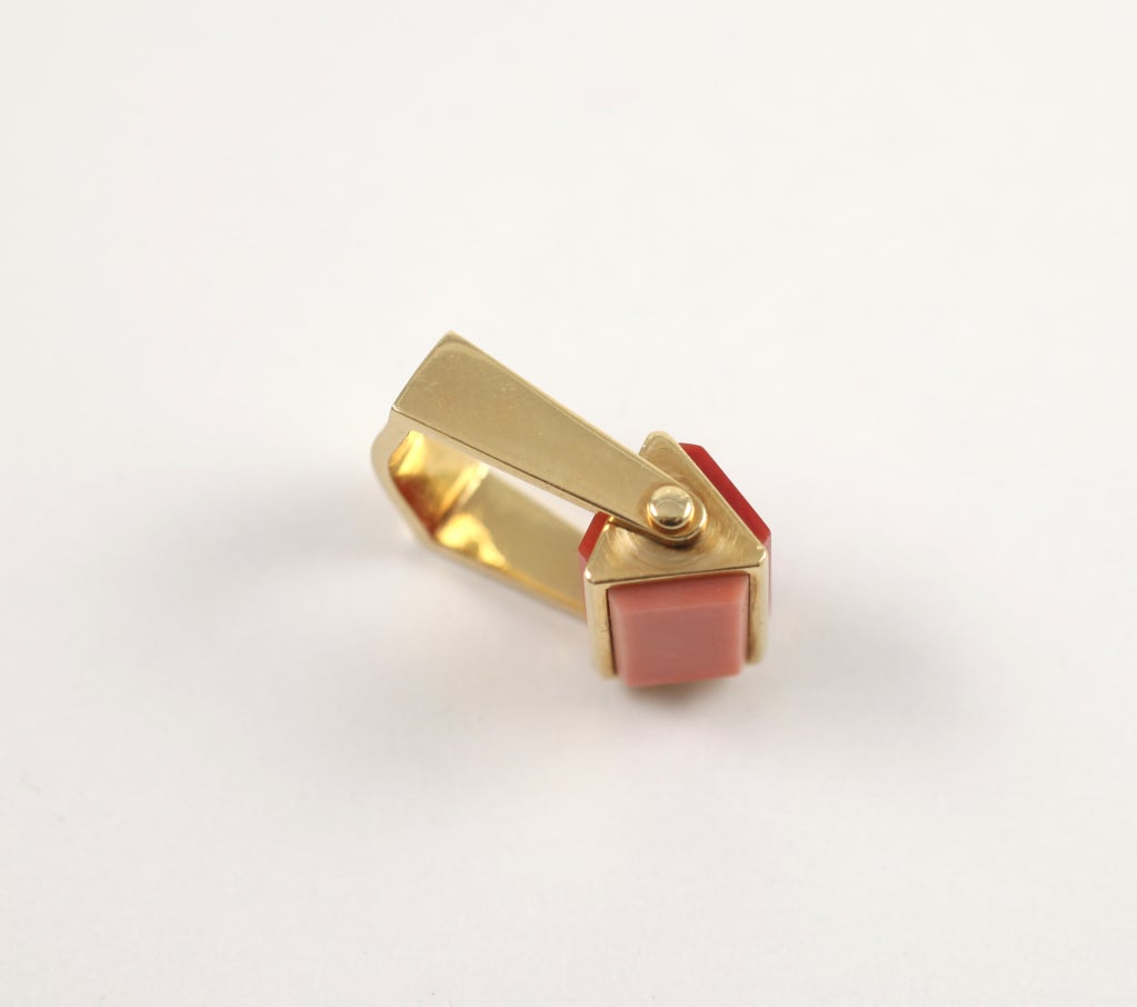 MS” 18k yellow gold ring with 3 different coral stones: red, pink and salmon. The ring is modern with a square shank and a rectangular three-sided central section that spins along its axis.