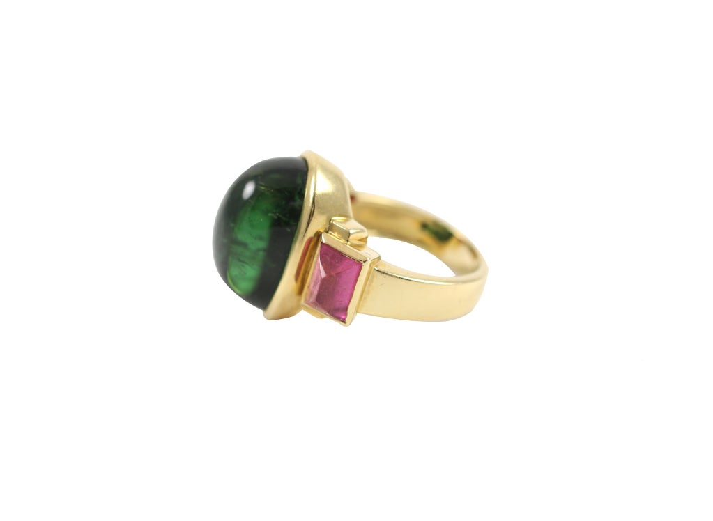 Set in 18K yellow gold. Large cabochon green tourmaline center stone with two pink tourmaline side stones. Center stone approximately 10ctws.