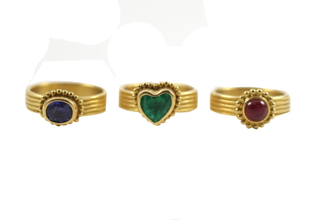 Maija Nemanis three bands of 22 yellow gold ridged bands. Ruby is .90 carat, Emerald is 1.39 carats and the Sapphire is .96 carats. Each stone is set with gold beading.