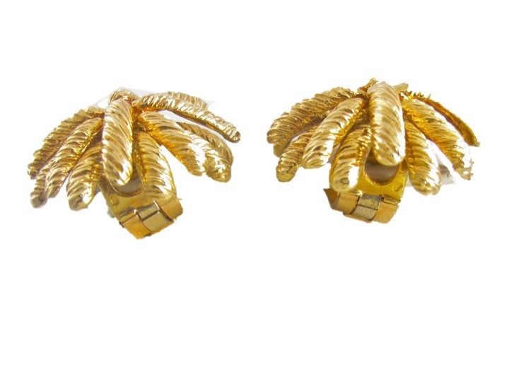 Earrings set in 18K yellow gold with a sculpted nature inspired design. Clip backing.