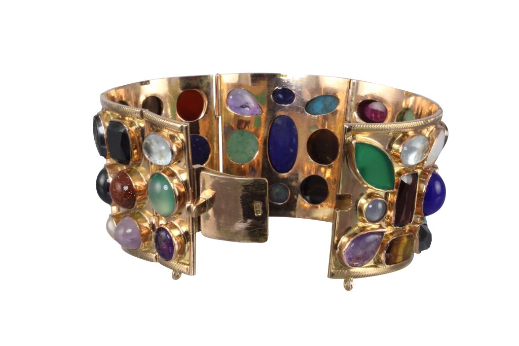 18k Rose gold funnel shaped cuff with carved, faceted and cabochon semi precious stones, encrusted in bezel mountings. The cuff is comprised of six hinged sections with a hidden clasp.