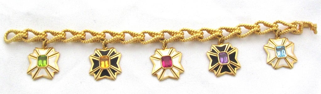 Maltese Cross charms in peridot, citrine, pink tourmaline, amethyst, blue topaz. Each stone is approximately 1.20cts.  Five white and black enamel charms with stones set in the center of each. 18k yellow gold rope link bracelet