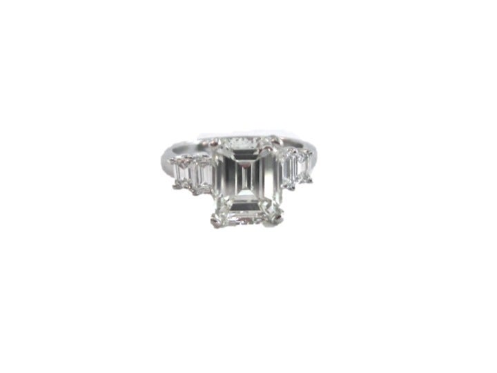 Beautiful emerald cut diamond ring. Center stone with GIA certs. Center stone is emerald cut weighing 3.44 carats, M color, VS1 clarity. Ring features two baguette diamonds on either side of center stone weighing a total of approximately .80cts.