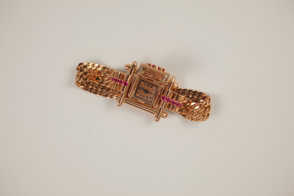 “Paul Ditishein” Ladies Hidden Watch Bracelet. Pink gold and decorated with 3.4ct of rubies and .37ct of diamonds