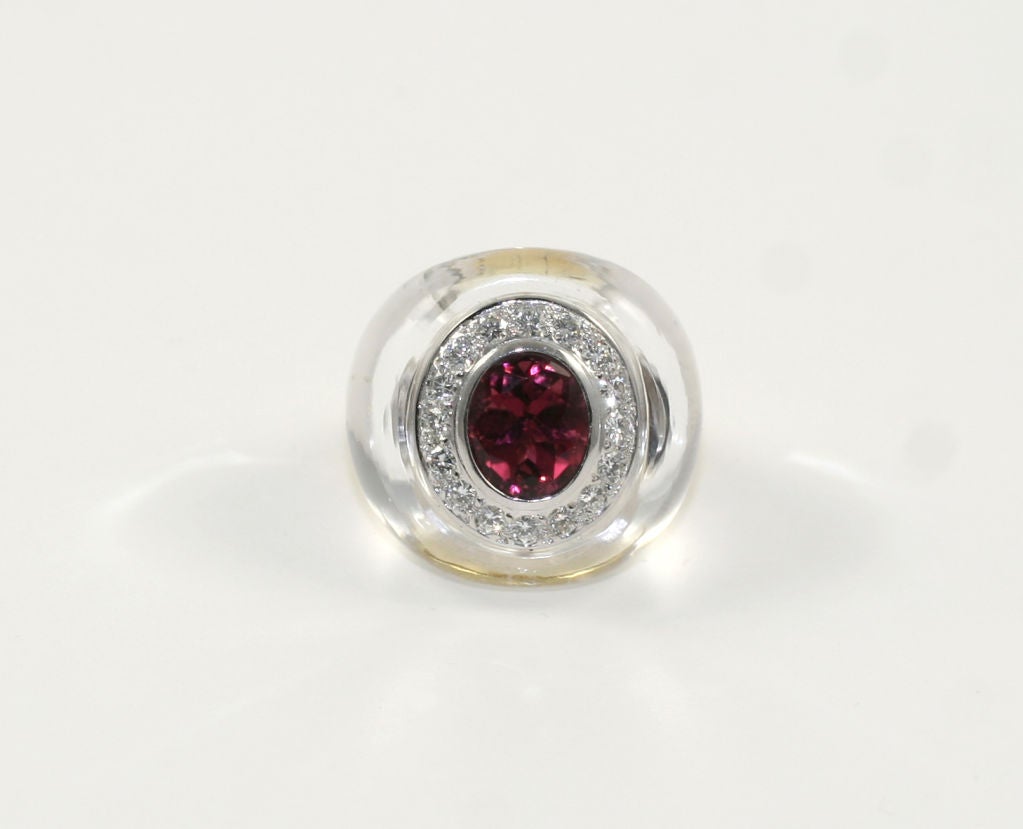 18k yellow gold ring with diamonds, tourmaline and quartz. Centrally-set is one 4.5ct oval faceted pink tourmaline. Tourmaline is surrounded by 16 brilliant diamonds(1.00ctw) that are VS, G-H. The diamonds are mounted in 18k white gold. Entire top