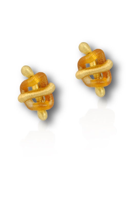 This earring is comprised of 18k yellow gold with a matte textured finish in an abstract form. Each earring contains one piece of hand carved citrine of one continual piece.