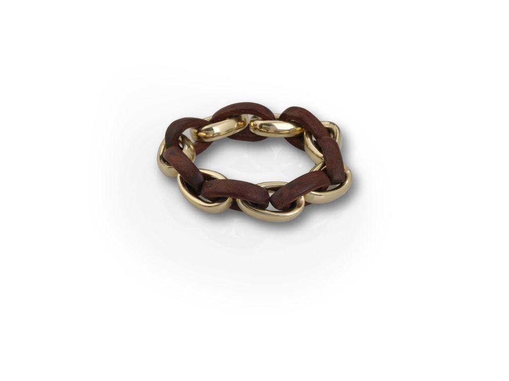 Teardrop shape link bracelet consisting of 18k yellow gold and handcarved rosewood.