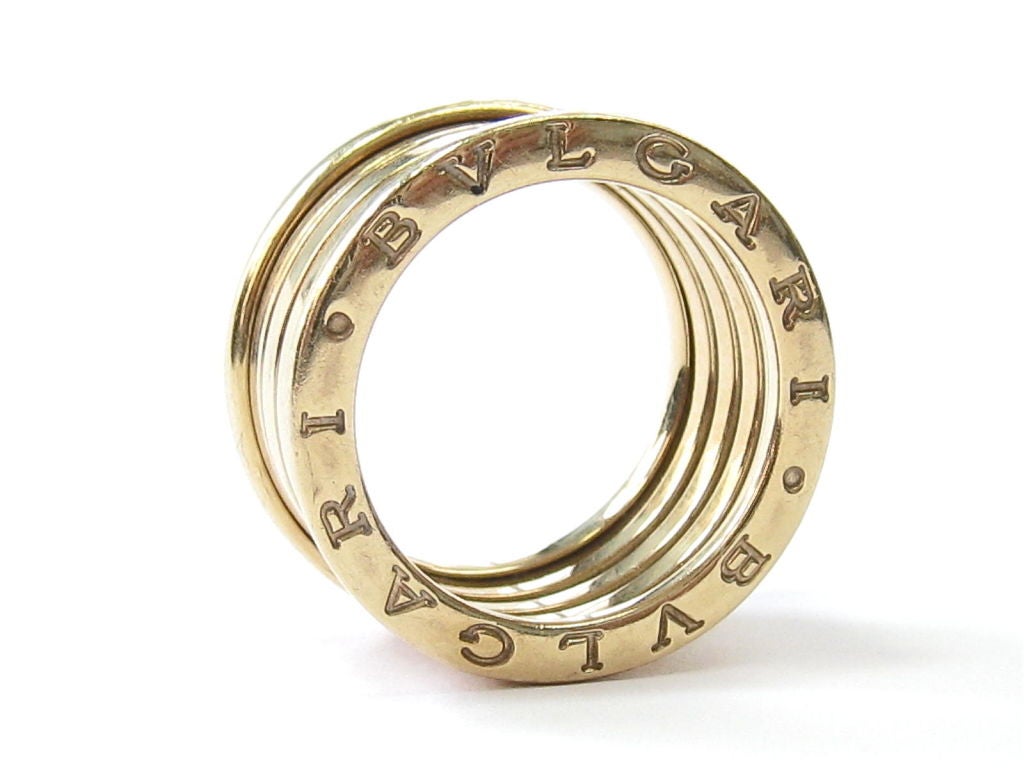 18kt yellow gold 5-band ring (3 internal bands). Engraved on both sides with double Bvlgari logo. Movable central part crafted with the unique Tubogas technique.  Size 7.5, cannot be resized. Original Bulgari box and outer box included. The price